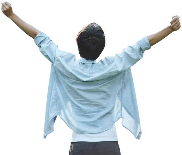 A happy man in a white shirt with his arms raised stands with his back to us.