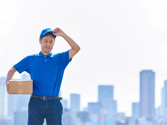 A worker in a blue t-shirt standing with his back to us.